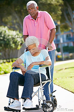 Senior Man Pushing Unhappy Wife In Wheelchair