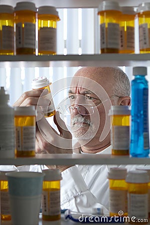 Senior man reading prescription bottle