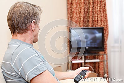 Senior man with remote control and tv-set