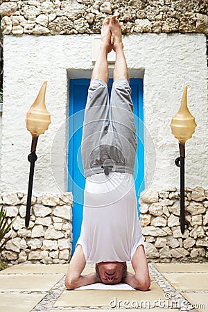 Senior Man Standing On Head In Yoga Position