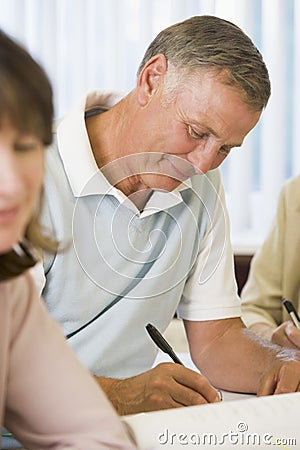 Senior man studying with other students