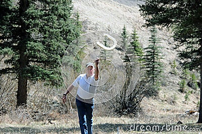 Senior man throwing horseshoe