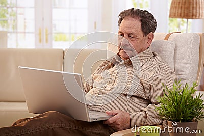 Senior man using computer at home