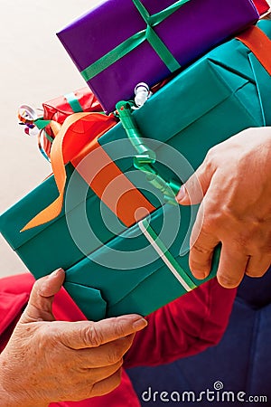 Senior sits and gets or give many gifts closeup