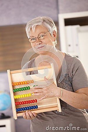 Senior teacher holding abacus