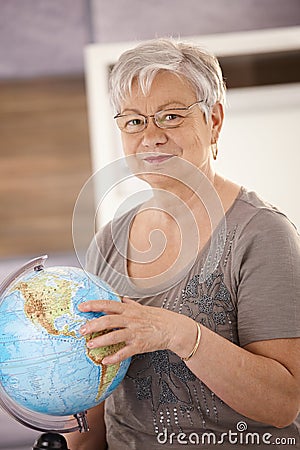 Senior teacher pointing at globe