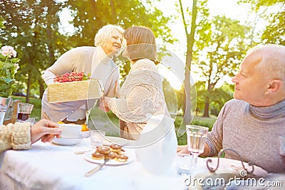 Senior woman bringing gift to birthday party