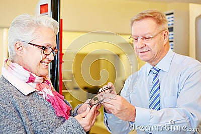 Senior woman buying glasses at