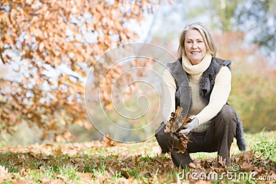 Senior woman collecting leaves on walk