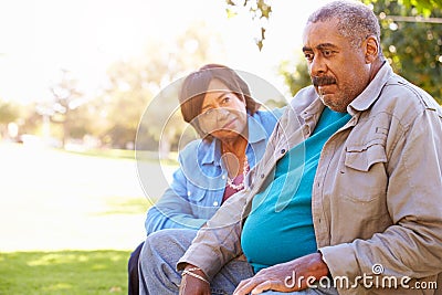 Senior Woman Comforting Unhappy Senior Husband Outdoors