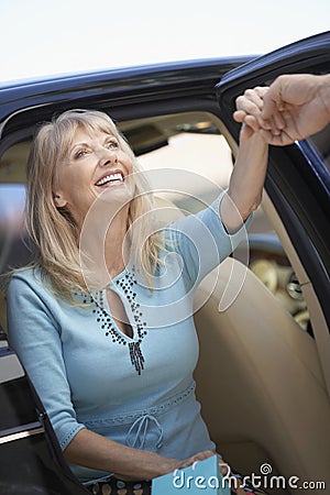 Senior Woman Coming Out Of A Car