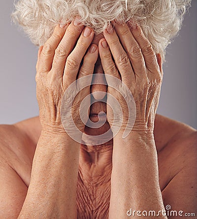 Senior woman covering her face with hands