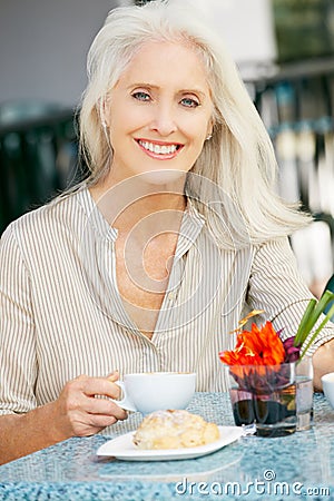 Senior Woman Enjoying Snack At Outdoor Cafe