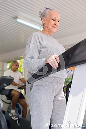Senior woman exercising in wellness club