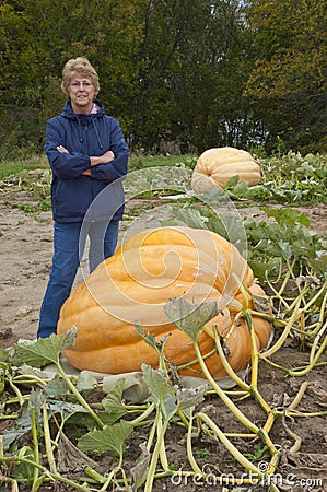 Senior Woman in Garden Growing Giant Pumpkin