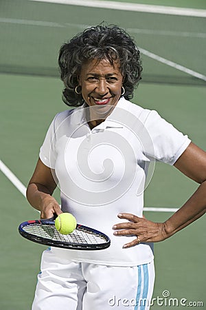 Senior Woman Playing Tennis In Court