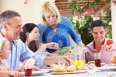 Senior Woman Serving A Family Meal