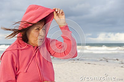 Senior woman and stormy weather at beach