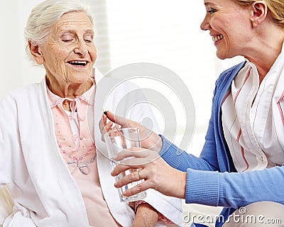 Senior woman taking pill with water