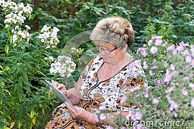 Senior woman using digital tablet in home garden