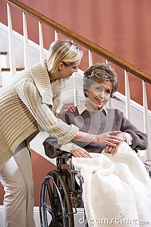 Senior woman in wheelchair at home with nurse