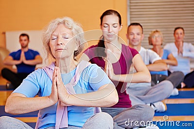 Senior woman in yoga class in gym