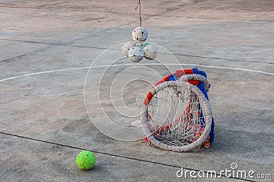 Sepaktakraw ball and hoop on concrete floor.