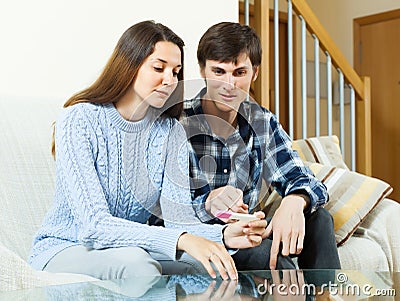 Serious couple with pregnancy test