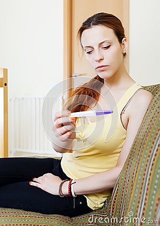 Serious girl with pregnancy test