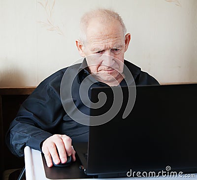 Serious old man working on a computer