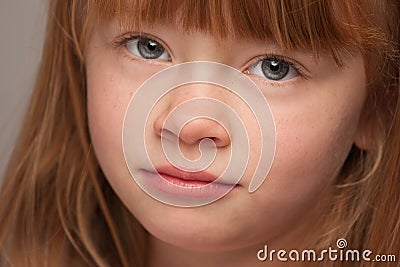 Serious Portrait of an Adorable Red Haired Girl on Grey