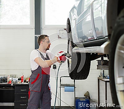 Serviceman in car workshop