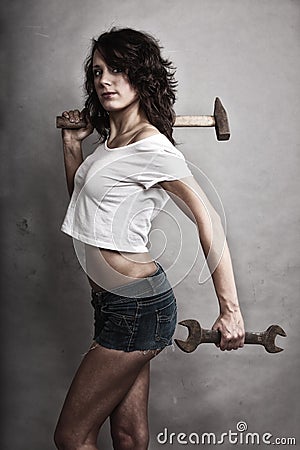 Sexy girl holding hammer and wrench spanner