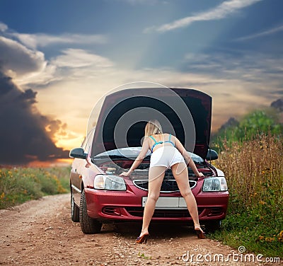 Sexy girl looking under the car hood