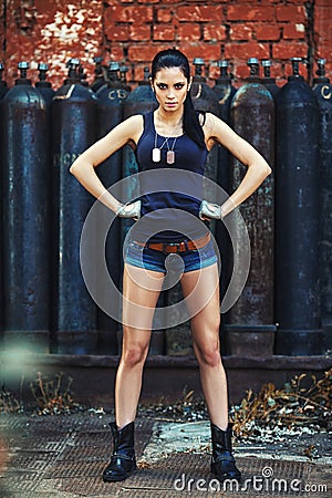 Sexy soldier woman on factory ruins