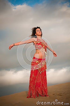 Sexy woman belly dancer arabian in desert dunes