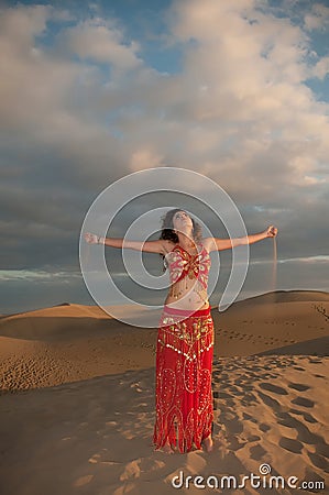 Sexy woman belly dancer arabian in desert dunes