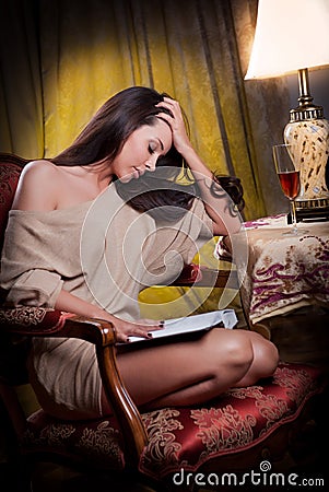 Sexy woman sitting in wood chair and reading in a vintage scene