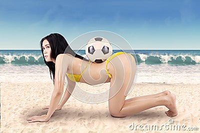 Sexy woman with soccer ball on vacation