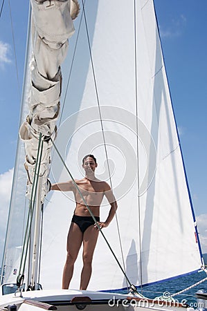 Sexy young man sailing on white yacht