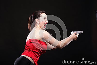 Sexy young woman - gun on black background