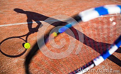 Shadow of a tennis player in action on a tennis court