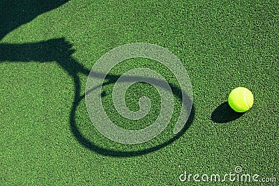 Shadow of a tennis racket in hand with a ball