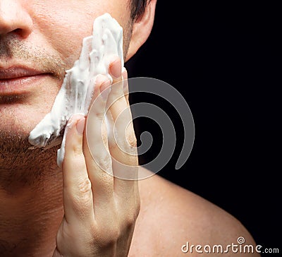 Young man applying a shaving foam