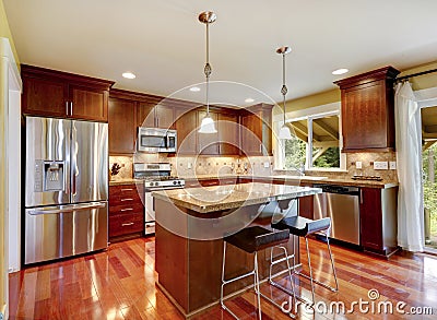 Shiny kitchen room with granite tops and steel appliances