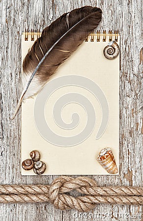 Ship rope, shells, feather, notebook and wood background