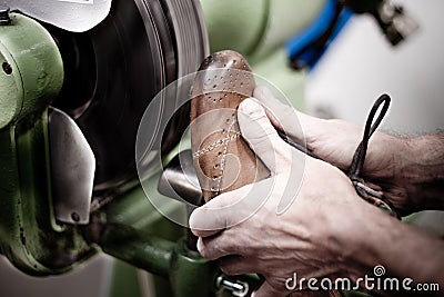 Shoemaker polishing sole of shoe