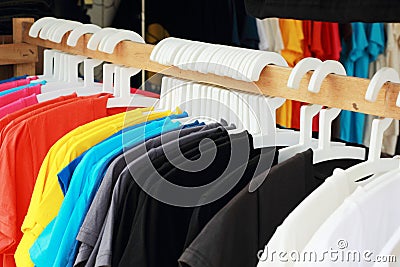 Shop shirts colorful fabric hanging on a rack.