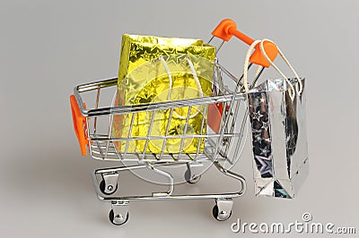 Shopping cart with packages on gray