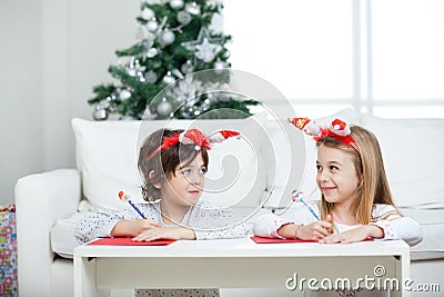 Siblings Writing Letter To Santa Claus During